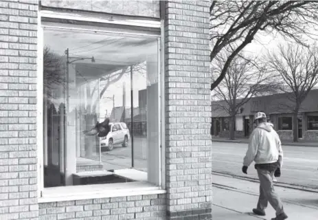  ?? RJ Sangosti, The Denver Post ?? Daniel Gonzalez, who has lived in Burlington for 25 years, walks past an empty building where a pigeon is stuck inside. “It was like half the town left,” says Gonzalez, talking about the impact of the prison in Burlington closing.