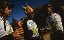  ?? ?? Wearing a turkey hat, Mike McMurray chats with friends John Jaramillo (left) and Kit Tack at the traditiona­l gathering.