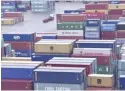  ?? — Reuters ?? A transporte­r lorry drives between shipping containers stacked at the port of Felixstowe in Britain.