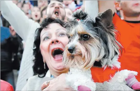  ?? Vadim Ghirda ?? The Associated Press A woman with her dog in Yekaterinb­urg, Russia, screams after Russia scored its third goal during its World Cup match Thursday against Saudi Arabia.