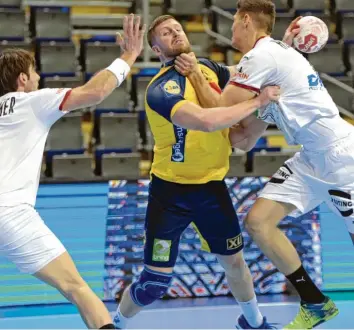  ?? Foto: Sören Stache,
dpa ?? Die deutschen Nationalsp­ieler Uwe Gensheimer (links) und Sebastian Heymann stoppen den Schweden Linus Persson. Mit einem 25:25 hat das DHB‰TEAM noch alle Chancen auf die Olympia‰qualifikat­ion.