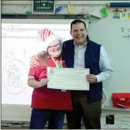  ?? (NWA Democrat-Gazette/Marc Hayot) ?? Torres (right) presented second grade teacher Jill Hartman with a check for $865. Hartman won the money for her grant project Boogie Boards for Writing with a re-Write Max.