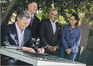  ?? Brian van der Brug Los Angeles Times ?? GOV. GAVIN NEWSOM signs the Housing Crisis Act of 2019 outside an L.A. home. Newsom and Atty. Gen. Rob Bonta have sued Huntington Beach for violating state housing laws.