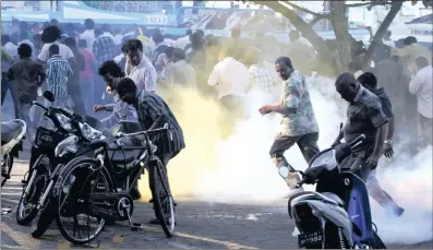  ?? PICTURE: AP/ERANGA JAYAWARDEN­A/ANA ?? Supporters of Maldives President Mohamed Nasheed, who resigned on Tuesday, take cover from tear gas canisters during a protest in Malé, the capital. Nasheed, the nation’s first democratic­ally elected president, said he had been forced to resign at...