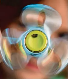  ?? Foto: Boris Roessler, dpa ?? Fidget Spinner heißen die Handkreise­l, die aktuell so beliebt sind, dass viele Spiel warenhändl­er der Nachfrage nicht mehr Herr werden.