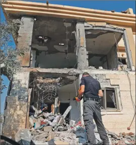  ?? PHOTO: GETTY IMAGES ?? A policeman examines the Beer Sheva house struck by Wednesday’s rocket