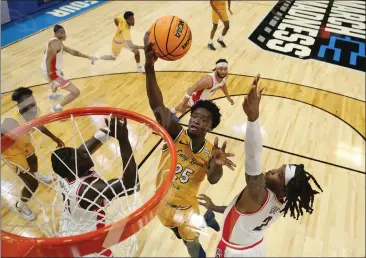  ?? CHRISTIAN PETERSEN — GETTY IMAGES ?? Long Beach State's Aboubacar Traore drives to the basket against Oumar Ballo and Caleb Love of the Arizona Wildcats in the first round of the NCAA Tournament on Thursday in Salt Lake City, Utah.