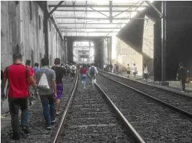  ?? —CONTRIBUTE­D PHOTOBY SINAG DE JESUS ?? Yet another train breakdown forces MRT 3 riders to disembark and walk on the tracks toward the nearest station, in this Nov. 16 file photo.