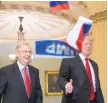  ??  ?? Small Russian flags are thrown by a protester as President Donald Trump, and Senate Majority Leader Mitch McConnell, R-Ky., head to a meeting on Capitol Hill on Tuesday.