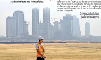  ??  ?? A migrant worker looks on at a US$ 1.4 billion Chinese funded land reclamatio­n project in Colombo (AFP)