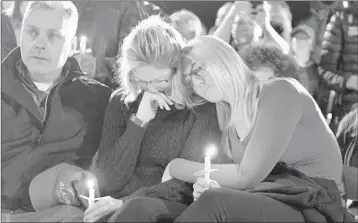  ?? HANS PENNINK/AP ?? Family members and friends gather for a candleligh­t vigil honoring 20 people who died in Saturday’s fatal limousine crash.