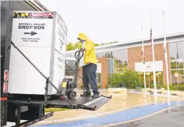  ?? JEFFREY F BILL/CAPITAL GAZETTE ?? Lydell Stewart, of Interstate Moving Company, delivers and installs an Official Ballot Drop Box at the Michael E. Busch Annapolis Library in Ward 2.