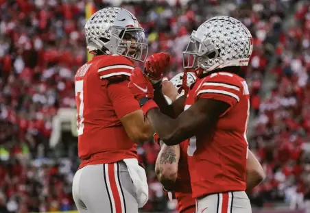  ?? Mark J. Terrill / Associated Press ?? Ohio State’s C.J. Stroud (left) passed for a school-record 573 yards — 347 of them to Jaxon Smith-Njigba (right) — in Pasadena.