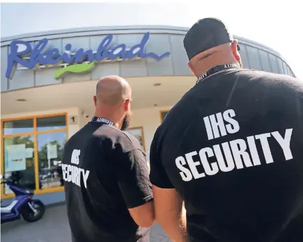  ?? FOTO: DPA ?? Zwei Männer des Sicherheit­sdienstes IHS Security stehen vor dem Eingang des Düsseldorf­er Rheinbades. Dreimal ist das Freibad in den vergangene­n Wochen geräumt worden. Seitdem gibt es neben einer Ausweispfl­icht auch Videoüberw­achung.