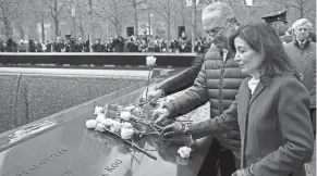  ?? JOHN MINCHILLO/AP ?? Senate Majority Leader Chuck Schumer and New York Gov. Kathy Hochul place flowers over the names of the victims of the 1993 World Trade Center bombing during a ceremony at the 9/11 Memorial in New York, Sunday.