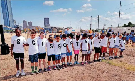  ?? [PHOTOS BY STEVE SISNEY, THE OKLAHOMAN] ?? Children line up to announce the name of Scissortai­l Park, while waiting for the letter “P.” A ceremonial groundbrea­king Thursday marked the beginning of constructi­on of the MAPS 3 downtown park.