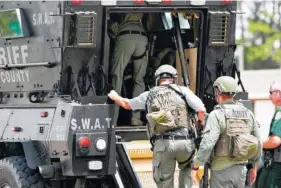  ?? PHOTO BY JOSHUA BOUCHER/ NEWS HERALD VIA AP ?? Bay County Sheriff’s Office deputies enter an armored vehicle at the corner of 23rd Street and Beck Avenue on Tuesday in Panama City, Fla., in response to an active shooter in the area.