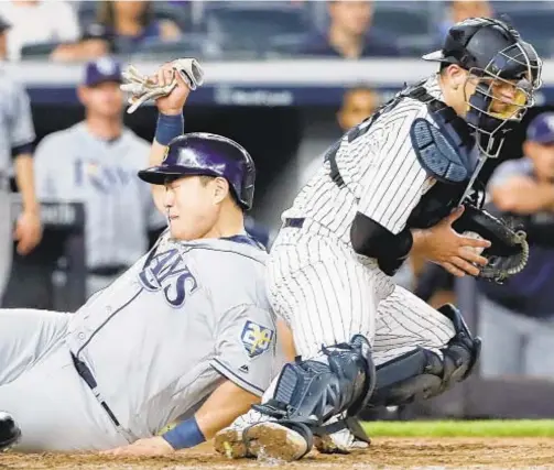  ?? GETTY ?? Ji-Man Choi slides safely past Austin Romine in fifth inning of Rays’ victory over Yanks Wednesday night at Stadium.