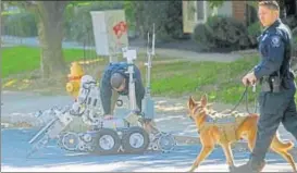  ?? REUTERS ?? ▪ A dog and a bomb disposal robot outside a post office which had been evacuated in Delaware.