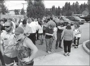  ?? AP/The Spokesman-Review/DAN PELLE ?? Parents gather in the parking lot behind Freeman High School in Rockford, Wash., to wait for students after a deadly shooting at the high school Wednesday.