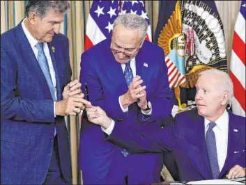  ?? Susan Walsh
The Associated Press ?? President Joe Biden hands the pen he used to sign the Democrats’ landmark climate change and health care bill to Sen. Joe Manchin, D-W.VA., as Senate Majority Leader Chuck Schumer of N.Y., watches on Aug. 16 at the White House.