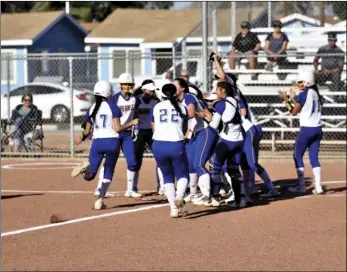  ?? PHOTO AARON BODUS ?? Contreras (17) is mobbed at the plate by her teammates following her round-tripper.