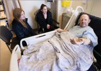  ?? MATHEW MCCARTHY, RECORD STAFF ?? Peter Grinbergs, a track coach at Wilfrid Laurier University, is visited by two of his runners, Sydney Pattison, left, and Bettina Boucher while he recovers in hospital, Sunday.