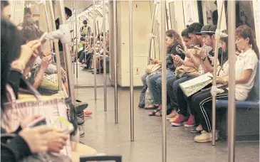  ??  ?? Commuters check mobile devices on a train. The Digital Economy and Society Index will track Thailand’s digital progress.