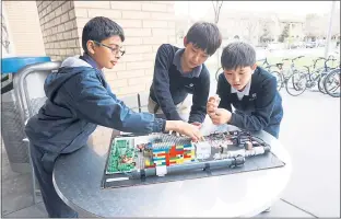  ?? PHOTO BY KHALIDA SARWARI ?? Harker School sixth-graders Kabir Ramzan, Dustin Miao and Jordan Labio’s project integratin­g rain collection and irrigation systems has garnered them a trip to Arkansas to compete in the final round of the First Lego League tournament in May.