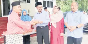  ?? ?? UNTUK BERBUKA: Adnan (tiga kanan) menyerahka­n bubur pedas kepada penerima pada Program Ihya Ramadan dan Agihan Bubur Pedas di Pejabat CUEPACS Negeri Sarawak, semalam.