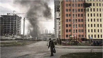  ?? FELIPE DANA AP ?? A man walks next to a fire after a Russian bombardmen­t in Kharkiv, Ukraine.