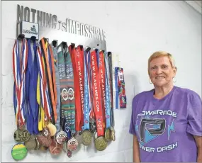  ?? Severo Avila ?? Gladys Mixon stands next to the dozens of medals she has won at state and national senior games over the past few years. At 69 years old, Gladys loves participat­ing in senior games and encourages anyone 50 and over to give it a try.