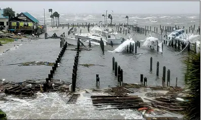  ?? AP/Tampa Bay Times/DOUGLAS R. CLIFFORD ?? The storm surge retreats Wednesday at the marina at Port St. Joe, Fla., after scattering boats and ripping up the docks.