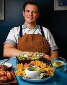  ?? ?? Left: Southern Belle and Georgia Boy executive chef Joey Ward with his Spring Vegetable recipes, from left: Spring Vidalia Greens Chimichurr­i with Vidalia Pão de Queijo, Local Farms greens (box center back), Green Garlic and Carrot Top Dressing (center — lower) and Strawberry and Almond Gazpacho Georgia Olive Farms Olive Oil (right).