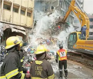  ?? Lagos Fire Service clearing rubbles after the fire ??