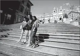  ?? FILIPPO MONTEFORTE/GETTY-AFP ?? Tourists pose legally this week for a photograph on the Spanish Steps in Rome. Sitting on the landmark has been made forbidden.
