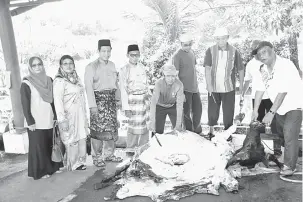  ??  ?? IBADAH KORBAN: Dayang Maimunah (dua kiri), Dr Abdul Rahman, Mahmud dan yang lainnya menyaksika­n kerja melapah daging kerbau semalam.