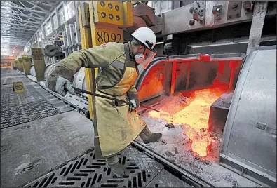  ?? Bloomberg file photo ?? A worker manipulate­s molten aluminum at a smelter in Krasnoyars­k, Russia. Russia would be among the countries affected by Commerce Department recommenda­tions to impose tariffs and set quotas on aluminum and steel imports.