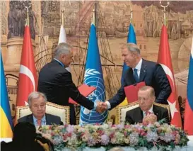  ?? KHALIL HAMRA/AP ?? Russian Defense Minister Sergei Shoigu, left, shakes hands with Turkish Defense Minister Hulusi Akar during a signing ceremony Friday in Istanbul that included U.N. Secretary-General Antonio Guterres, seated left, and Turkish President Recep Tayyip Erdogan.
