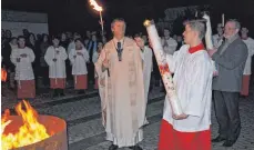  ?? FOTOS: HANSJÖRG STEIDLE ?? Feier der Osternacht in Westerheim: Pfarrer Karl Enderle entzündet die Osterkerze­n von Westerheim und Ennabeuren.