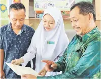  ??  ?? LIHAT: Bujang (kanan) melihat keputusan cemerlang 9A yang diperoleh Qurratu Ain yang turut ditemani bapanya, Bujang Abdul Manan.