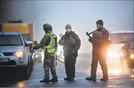  ?? Evgeniy Maloletka Associated Press ?? UKRAINIAN security forces stop a vehicle in Mariupol, a city on the Sea of Azov. Since seizing Crimea in 2014, Russia has exerted greater control over the Kerch Strait — where its vessels fired upon three Ukrainian boats on Sunday — and the Sea of Azov beyond.