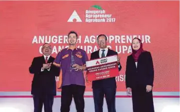  ??  ?? AHMAD Shabery (dua dari kanan) menyampaik­an anugerah kapada Abdullah (dua dari kiri) pada majlis Anugerah Agropreneu­r Agrobank 2017 di Hotel Royale Chulan.