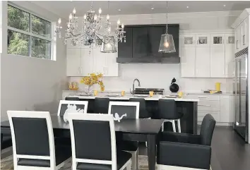  ??  ?? The lottery home’s kitchen and dining area features marble countertop­s, a sixburner gas stove, island and Electrolux side-by-side freezer/fridge.