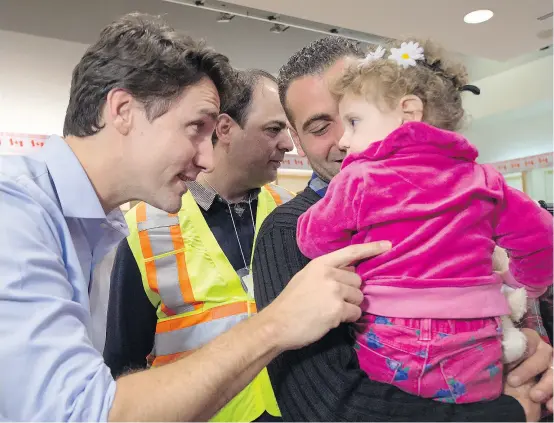  ?? NATHAN DENETTE / THE CANADIAN PRESS ?? Prime Minister Justin Trudeau greets refugees from Syria during their arrival in Toronto, on Friday, Dec. 11, 2015.