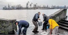  ?? FOTO: BERNAT ARMANGUE/DPA ?? Bewohner in Cherson holen Wasser vom Ufer des Flusses Dnipro im Süden der Ukraine.