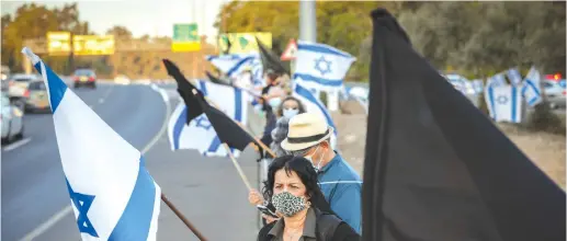  ?? ( Nati Shohat/ Flash90) ?? PROTESTERS DEMONSTRAT­E against Prime Minister Benjamin Netanyahu, on Highway 1 between Jerusalem and Tel Aviv, on Tuesday.