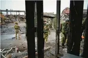  ?? AP ?? Russian soldiers on Wednesday walk through the wreckage of the steel works that was under siege in Mariupol, Ukraine.