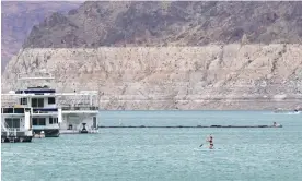  ?? J Brown/AFP/Getty Images ?? A woman paddles across the water at Lake Mead, Nevada last week. Photograph: Frederic