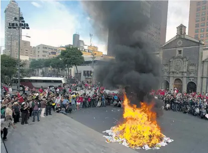  ??  ?? Demonstran­ten in Mexiko-Stadt verbrennen Flaggen und Wahlplakat­e politische­r Parteien.